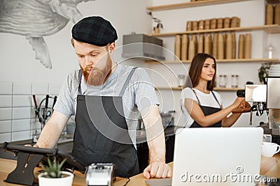 Coffee Business Concept - Young handsome bearded bartender, barista or manager posting the order from guest in digital Stock Photo