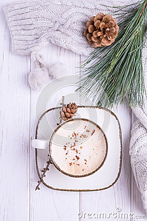 Coffee cappuccino with ceylon cinnamon, a branch of a pine tree and knitted accessories on a white wooden background Stock Photo