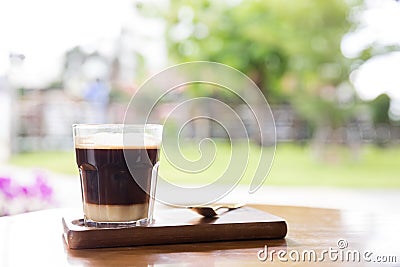 Coffee with condensed milk. Coffee with condensed milk in a transparent glass.Vietnamese coffee with condensed milk in glass cups. Stock Photo