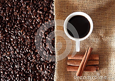 Coffee cup with beans and cinnamon sticks Stock Photo