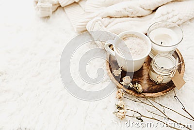 Coffee cup with candles in cozy home atmosphere. Warm sweater Stock Photo