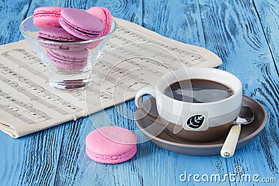 Coffee cup with macaroons and musical notes in background Stock Photo