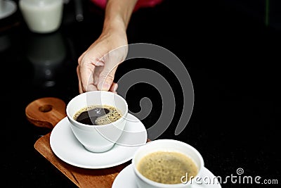 Coffee cup on plate and hand barista Stock Photo