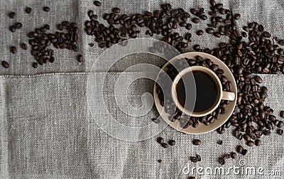 Coffee cup with roasted coffee beans on linen background. Mug of black coffe with scattered coffee beans. Fresh coffee Stock Photo