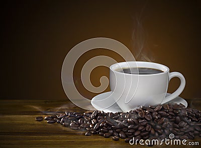 Coffee cup with roasted brown coffee beans and smoke on wooden t Stock Photo