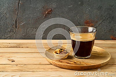 Coffee cup and small caramel nut tart on wooden table Stock Photo