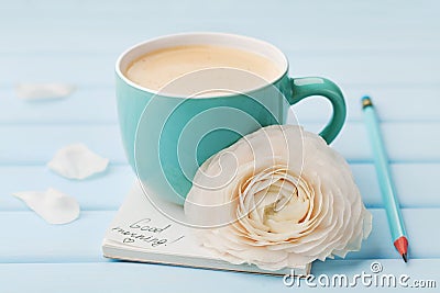 Coffee cup with spring flower and notes good morning on blue rustic background, breakfast Stock Photo