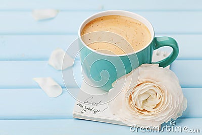 Coffee cup with spring flower and notes good morning on blue rustic background, breakfast Stock Photo
