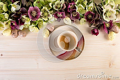 Coffee cup top view over light wooden background with spring flowers and Easter Eggs Retro style pastel colors Stock Photo