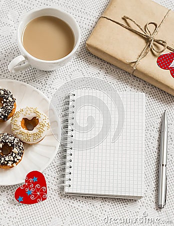 Coffee, donuts, homemade Valentine's day gift , red paper hearts, blank open notebook Stock Photo