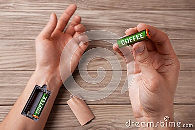 Coffee energizes. Hand of man with slot for charging batteries Stock Photo