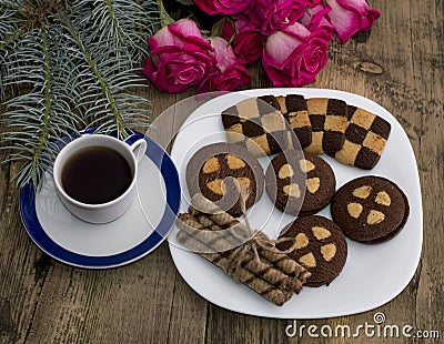 Coffee, fir-tree branch, roses and a plate with baking Stock Photo