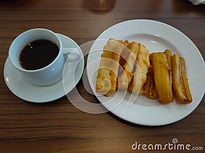 Coffee and frie banana on wooden table Stock Photo