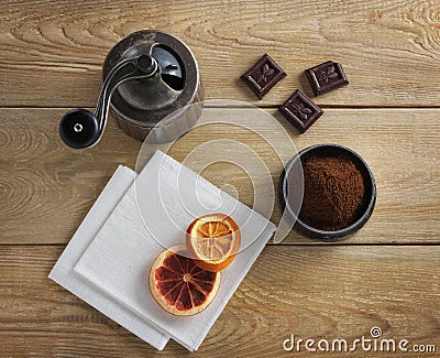 Coffee grinder, chocolate & dried orange on a wooden table Stock Photo