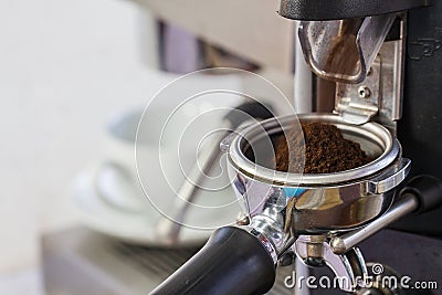 Coffee grinder grinding freshly roasted coffee beans Stock Photo