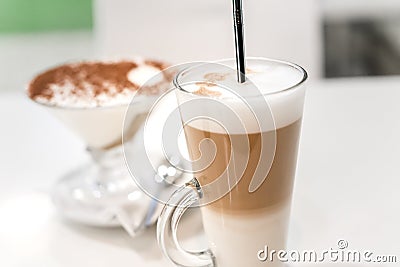 Coffee latte with frothy milk in tall glass, rustic style, white background Stock Photo