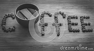 Coffee letters made of beans and cup on vintage boards. Black and white picture Stock Photo