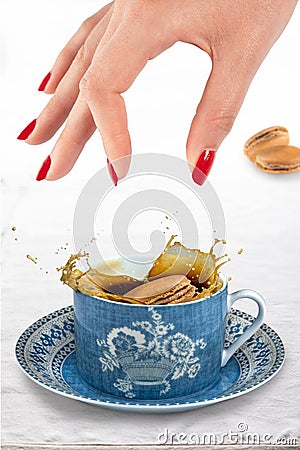 Coffee macaroon being dropped into a cup of coffee Stock Photo