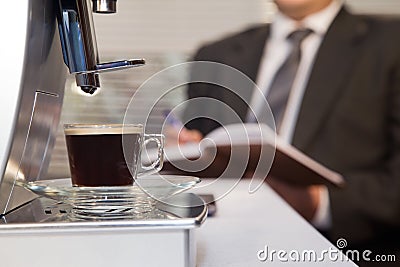 Coffee machine with cup of hot espresso in office Stock Photo