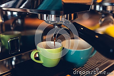 Coffee machine preparing espresso and pouring into colored cups Stock Photo