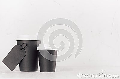 Coffee mockup - different size black paper cups with white cap and blank label on white wood table with copy space, coffee shop. Stock Photo