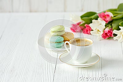 Coffee, pink and white tulips and macarons on the white wooden table Stock Photo