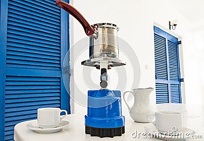 Coffee pot on a primus stove with cups on summer veranda. Stock Photo