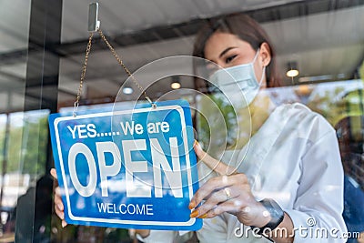 Coffee shop asian woman owner with face mask, open after lockdown quarantine in cafe covid-19 preventing Stock Photo