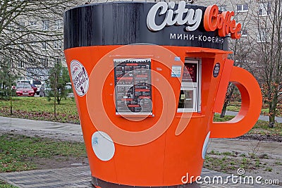 Coffee shop stall in shape of orange mug with inscription at top Editorial Stock Photo