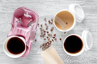 Coffee to go. Coffee cups with cover and coffee beans on wooden table backound top view Stock Photo
