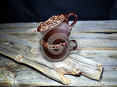 Coffeebeans in some ceramic coffee cups on a wooden table Stock Photo