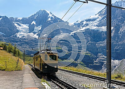 A cog wheel train traveling on the mountain Railway from Wengen to Kleine Scheidegg station Stock Photo