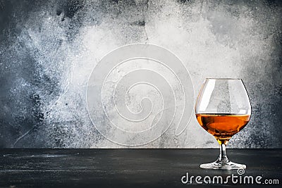 Cognac or brandy in wine glass, gray stone bar counter background, selective focus Stock Photo