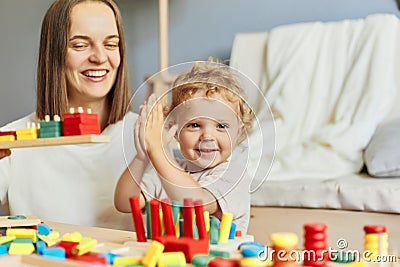 Cognitive development puzzles. Montessori learning approach. Fun family activities. teacher or mother playing with baby with Stock Photo