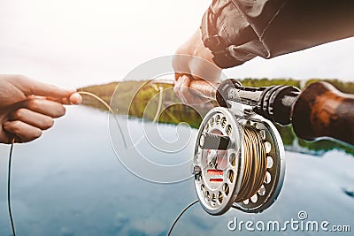 Coil of fly fishing rope, man hands holding rod Stock Photo