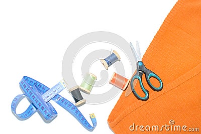 Coil with thread, scissors and ruler on a piece with a bright cloth, on a white background Stock Photo