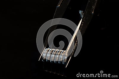 Coil and tweezers for rda vaping with black background Stock Photo