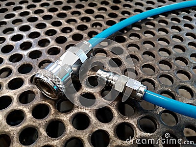 Close-up. coiled blue hose and quick coupler set on metal sheet background Stock Photo