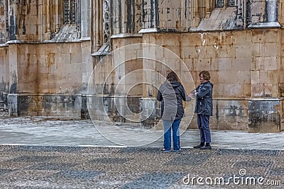 View of tourists talking on exterior close to the Gothic exterior facade of the Monastery of Batalha, Mosteiro da Batalha, Editorial Stock Photo