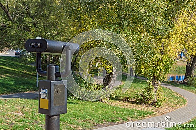 Coin binoculars on a background of landscape: green trees and gr Stock Photo