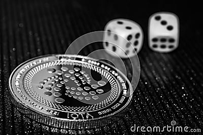 Coin cryptocurrency iota and rolling dice. Editorial Stock Photo