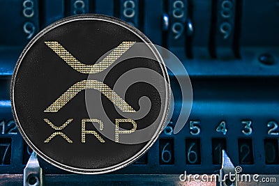 Coin cryptocurrency XRP against the numbers of the arithmometer. ripple Editorial Stock Photo