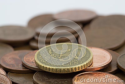 Coin of fifty euro cents on several bronze coins of five euro cents. White background Stock Photo