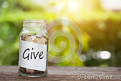 Coin in jar with give text natural background. Charity Concept Stock Photo