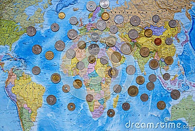 Coins of different countries on the world map background Editorial Stock Photo
