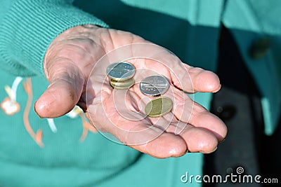The coins are in the hands of the old lady. An elderly woman with money in her hands. Poverty alms Stock Photo