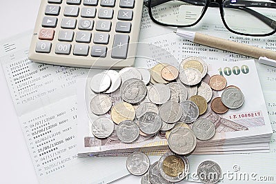 Coins, money, calculator, glasses and pen on savings account passbook Stock Photo