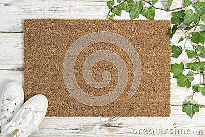 Coir doormat mockup with green plant decoration on white wooden background Stock Photo