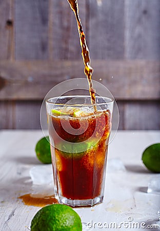 Cola that pour in glass with ice, lime and rum Stock Photo