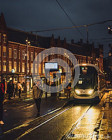 A cold autumn evening in Amsterdam, a tram stops outside Centraal Station. Editorial Stock Photo